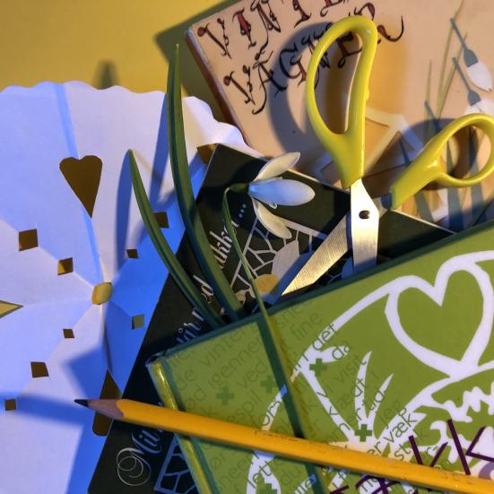 Gækkebrev, saks, pen og bøger med gækkevers